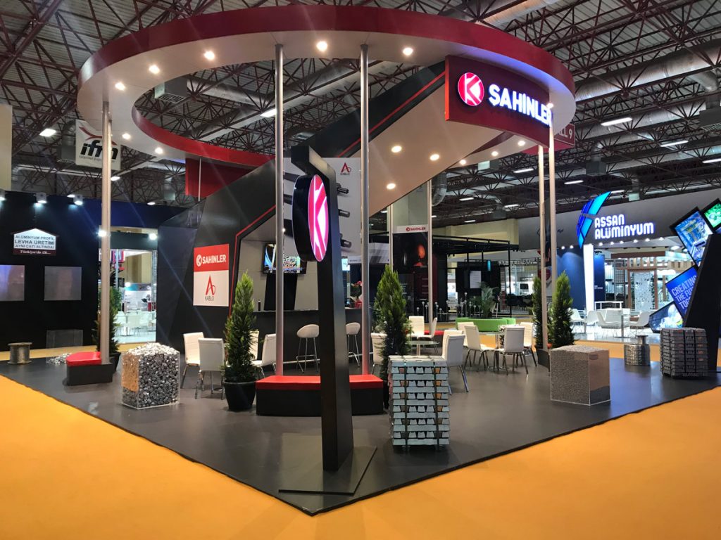 A modern design of a tall and open, circular Exhibition Stand in red and black colours