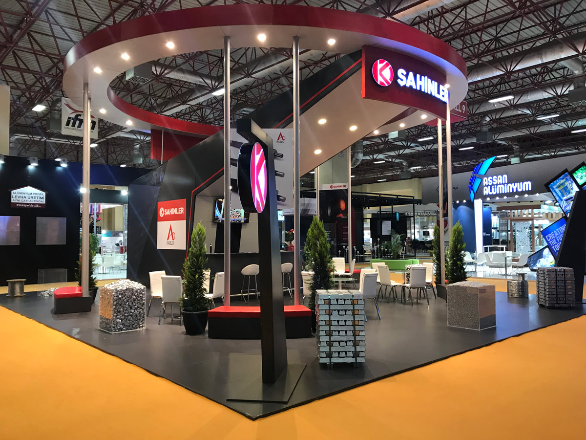 A modern design of a tall and open, circular Exhibition Stand in red and black colours