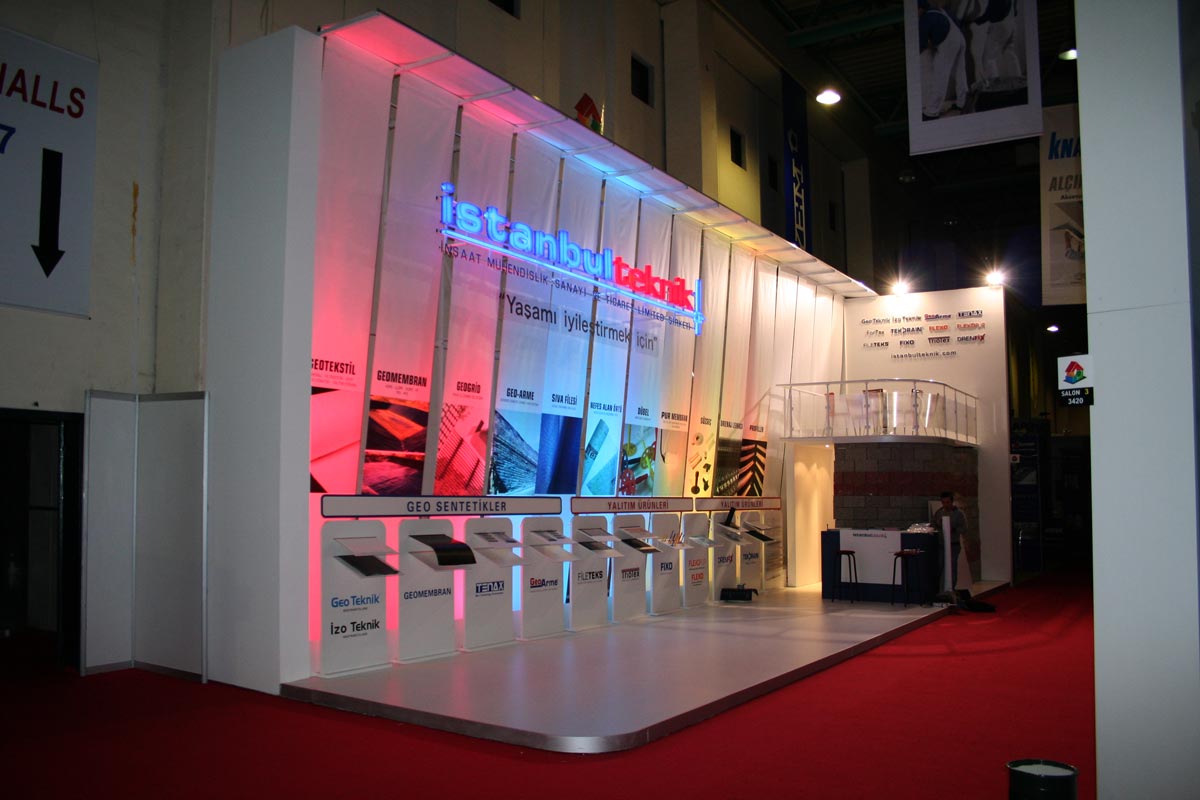 A white exhibition stand for Istanbul Teknik showcasing building materials with LED lights