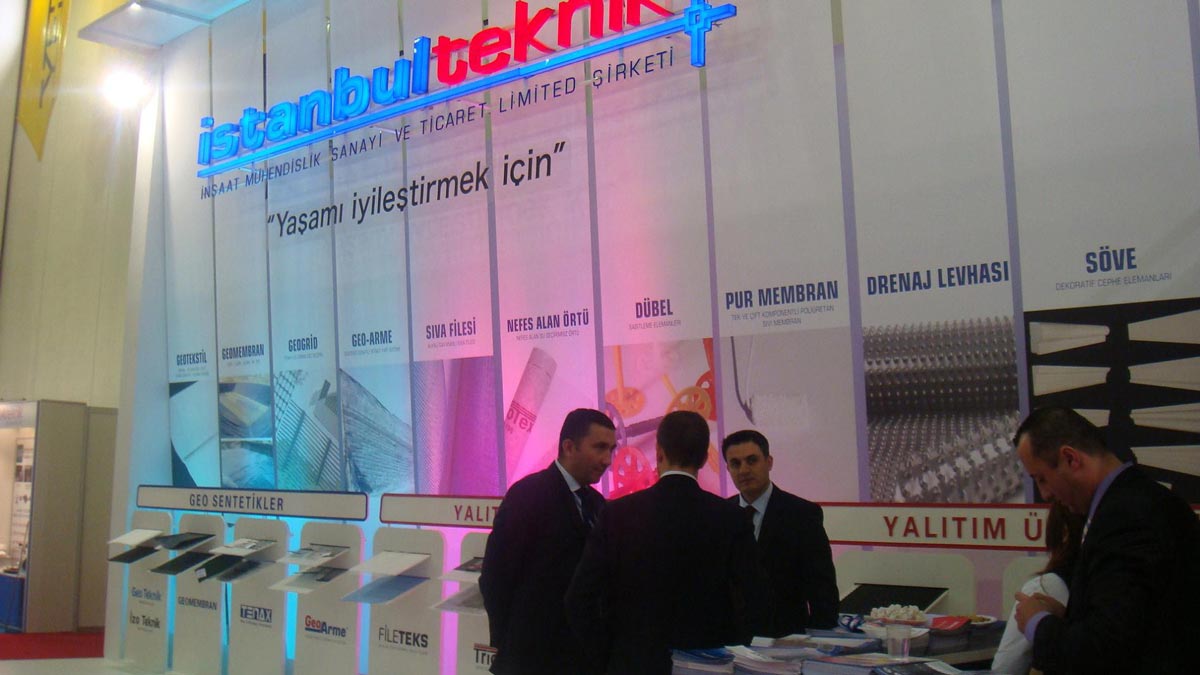 Few men standing inside a colorful exhibition stand