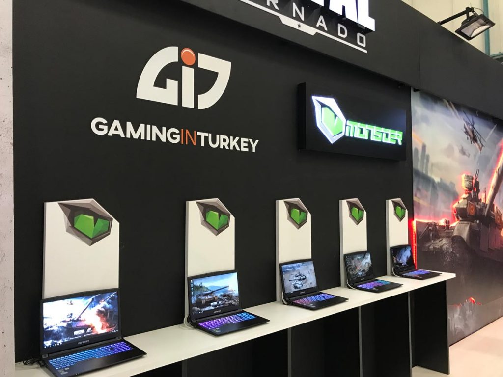 A dark piece of exhibition stand displaying monster laptops