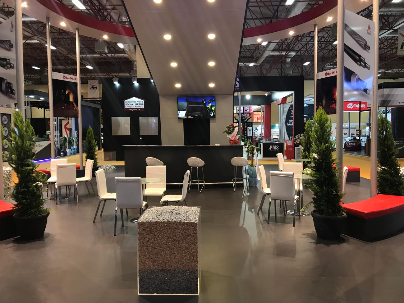 Inside of a large Exhibition Stand of a visitor area with white tables and chairs in London