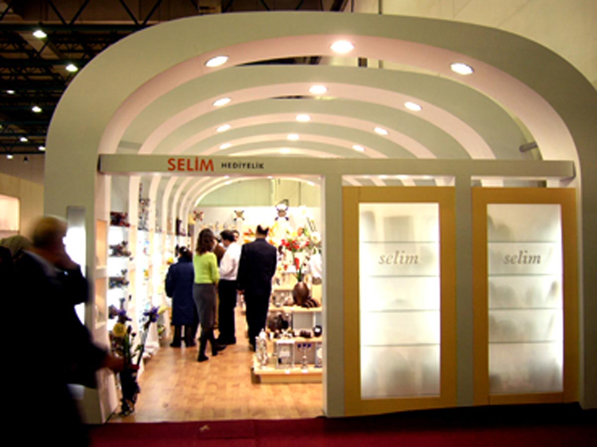 People walking under the white arches of an Exhibition Stand