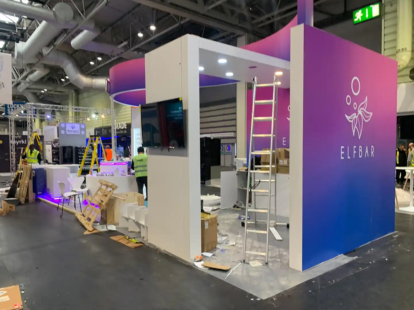 Pink and blue Elf bar Trade Stand under construction. White structure with TV installed in the middle