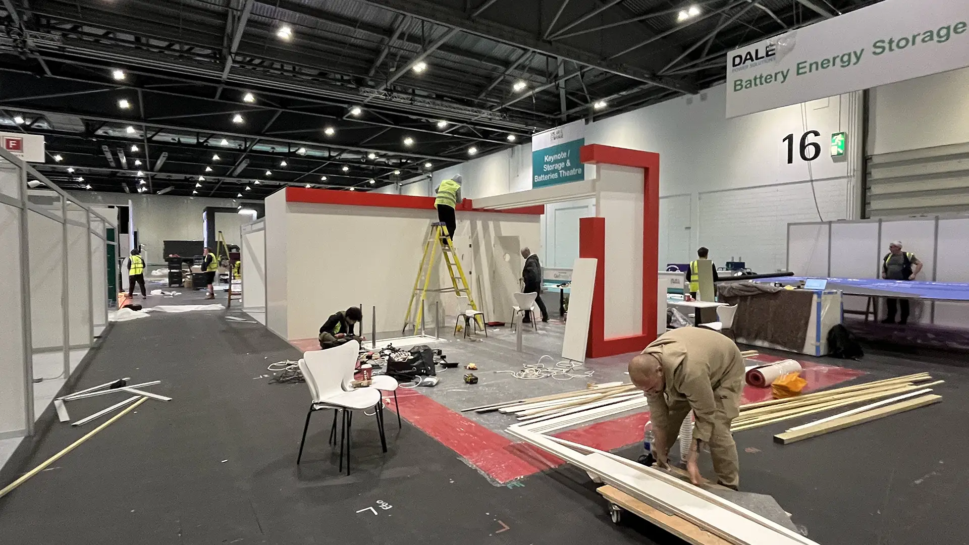 People working in a white and red Exhibition Booth construction.